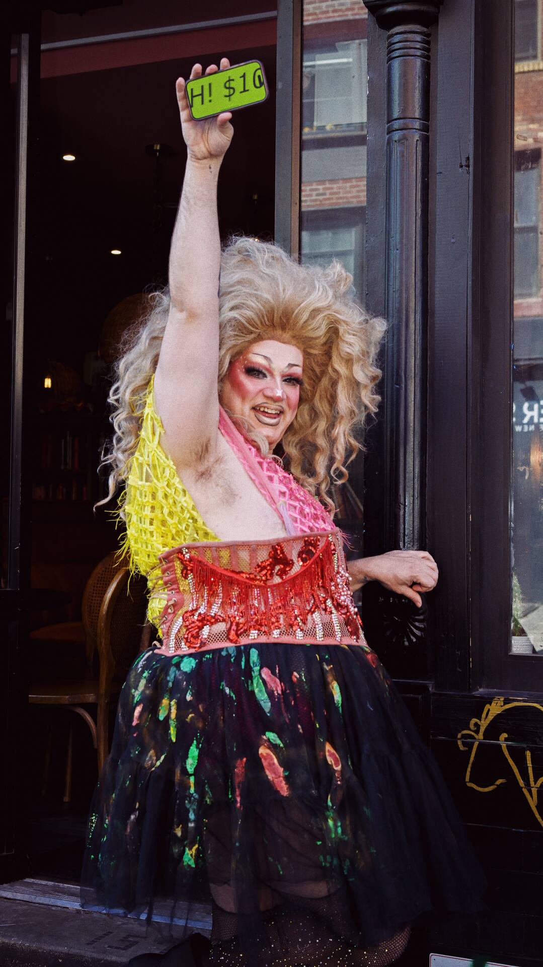 Zalika Parsons outside a venue entrance, arm raised